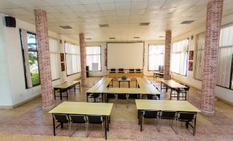 a large , empty conference room with rows of tables and chairs set up for meetings at Belvedere Hotel