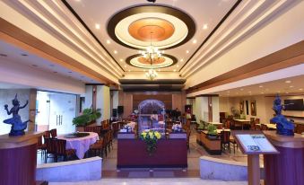 a large dining room with a round ceiling and two tables , one of which has a bowl of food on it at Asian Hotel