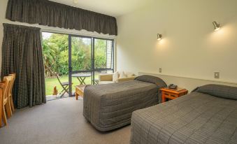 a hotel room with two beds , one on the left side and the other on the right side of the room at Sunset Motel