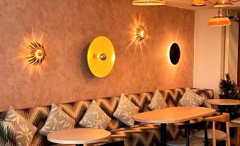 a dining room with a wooden table , chairs , and a couch in the background at Bayview Hotel