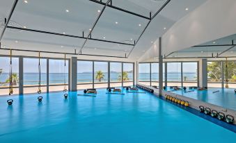 an indoor swimming pool surrounded by windows , with a view of the ocean in the background at Le Méridien Lav, Split