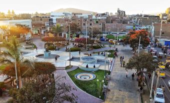 a bustling city square with a fountain in the center , surrounded by people walking and standing around at Hotel Marbella