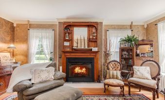 a cozy living room with a fireplace and a large mirror on the wall , creating a warm and inviting atmosphere at Van Winkle Inn