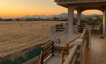 a beautiful sunset view of a field with a terrace and wooden decking , taken from an elevated position at Il Tramonto