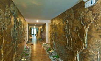 a long , narrow hallway with a stone wall on one side and a wooden floor on the other at Muong Thanh Dien Chau Hotel