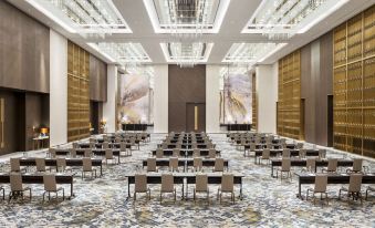 a large conference room with rows of chairs arranged in a semicircle , providing seating for a group of people at Waldorf Astoria Kuwait