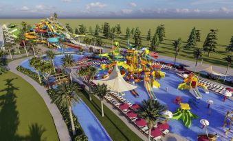 a large , colorful water park with various water slides and attractions is surrounded by green grass and palm trees at Rixos Water World Aktau