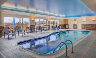 an indoor swimming pool with a blue ceiling , surrounded by lounge chairs and tables , and equipped with pool equipment at Residence Inn St. Louis Westport
