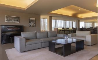 a modern living room with a large sectional sofa , a coffee table , and multiple chairs at Hotel Fundador