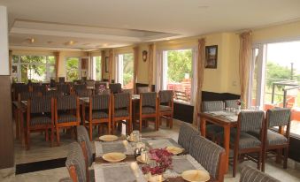 a dining room with several tables and chairs arranged for a group of people to enjoy a meal together at Hotel Srinagar