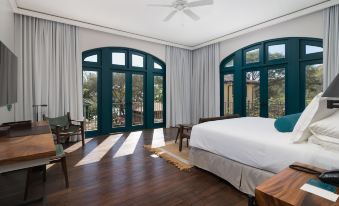 a spacious bedroom with hardwood floors , large windows , and a bed in the center of the room at Santarena Hotel at Las Catalinas