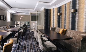 a dining room with a long wooden table , several chairs , and a television mounted on the wall at The Seafield Arms-Cullen