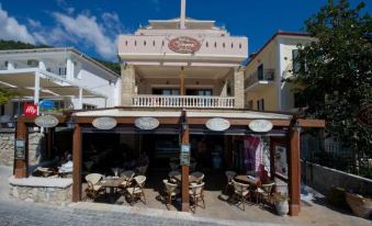 a small town with a restaurant on the ground floor , surrounded by buildings and trees at Utopia