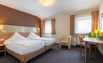 a hotel room with two beds , one on the left and one on the right side of the room at Hamm