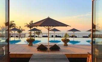 a large swimming pool with umbrellas and lounge chairs , overlooking a body of water and the ocean at Sankara Hotel & Spa Yakushima