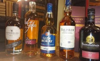 a variety of liquor bottles on a shelf , including glen moray , talisker and humister 's victory at The Hunters Moon