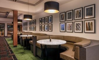 a dining area with several tables and chairs , some of which are arranged around a large dining table at Blacktown Tavern