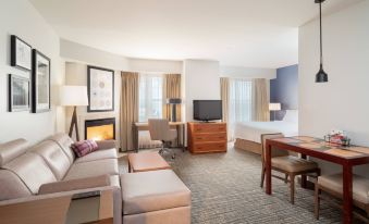 a hotel room with a bed , a couch , a tv , a dining table , and a fireplace at Residence Inn New Bedford Dartmouth