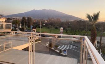 a parking lot with cars and a view of a mountain in the background during sunset at Victoria Hotel
