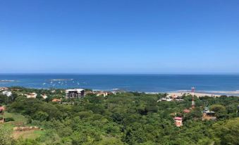 a panoramic view of a coastal town with buildings , trees , and the ocean in the background at Wyndham Tamarindo