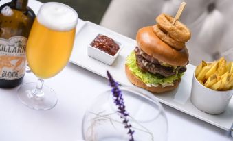 a white dining table with a plate of burgers , a cup of beer , and a glass of wine at The Victoria