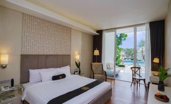 a modern bedroom with a large bed and sliding glass doors leading to a balcony at Java Heritage Hotel Purwokerto