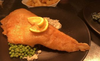 a dining table with a plate of food on it , including a piece of fish and some vegetables at The Moorland Hotel