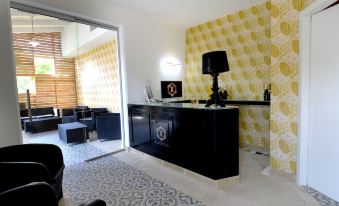 a modern office space with yellow and white patterned wallpaper , a black desk , and a black couch at X Hotel