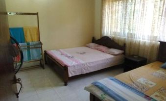 a bedroom with a bed , nightstand , and window curtains , as well as a desk and chair at Rivers Edge