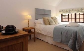 a cozy bedroom with a large bed , two nightstands , and a lamp on each side of the bed at Barton B&B