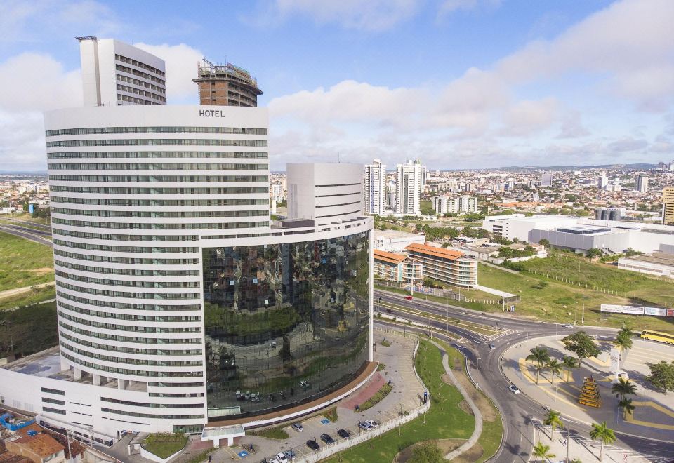 a large white building with a curved facade is surrounded by other buildings and roads at Slaviero Campina Grande