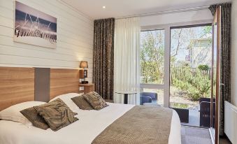 a large bed with a wooden headboard and white linens is in a bedroom with a sliding glass door at La Cremaillere