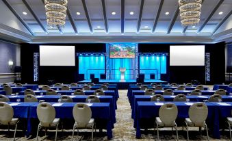 a large conference room with multiple rows of chairs arranged in front of a stage at The Grand Hotel Golf Resort & Spa, Autograph Collection