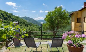 a beautiful outdoor setting with two chairs placed on a wooden deck overlooking a mountainous landscape at Villa