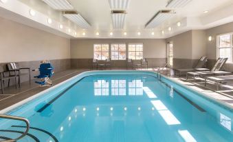 an indoor swimming pool with a clear blue water , surrounded by white walls and equipped with lounge chairs at Residence Inn West Springfield