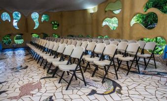 a large room filled with rows of white chairs arranged in a semicircle , providing seating for a large group of people at Laguna Lodge