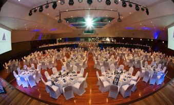 a large banquet hall with tables covered in white tablecloths and chairs arranged for a formal event at The Executive Inn, Newcastle