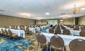 a large conference room with rows of chairs and tables , a projector screen , and a chandelier at Best Western Plus Strongsville Cleveland