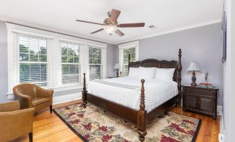 a spacious bedroom with hardwood floors , a large bed , and a ceiling fan in the room at Steeles Tavern Manor