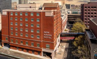a brick building with a large sign on the side , located in a city setting at New Haven Hotel
