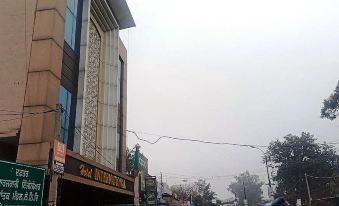 a city street with a tall building on the left side and a clock tower on the right side at Hotel International