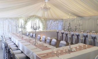 a long dining table set up for a wedding reception , with several chairs arranged around it at Rettendon Lodge