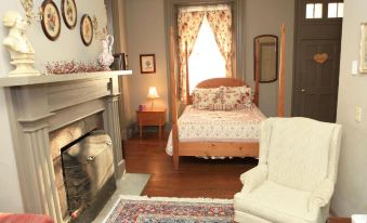 a cozy bedroom with a large bed , a fireplace , and a rug on the floor at Lafayette Inn