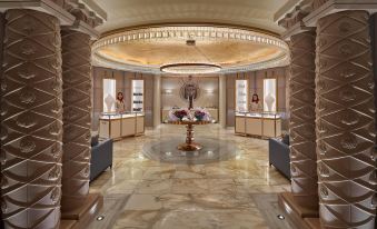 a luxurious store with marble floors , a circular centerpiece in the center , and two large mirrors on the walls at Mandarin Oriental, Doha