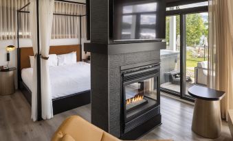 a spacious bedroom with a large bed and a fireplace , creating a warm and inviting atmosphere at Esterel Resort