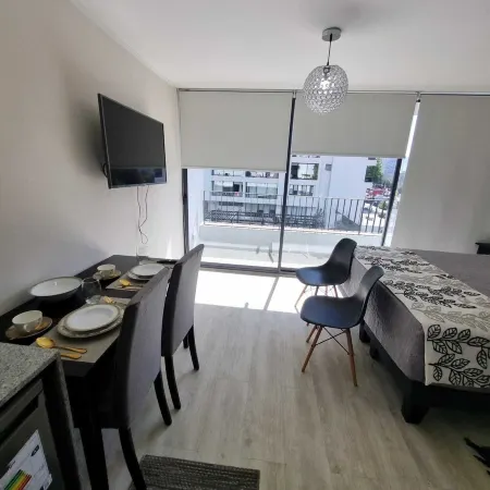 In front of Hospital U. de Chile with parking lot.