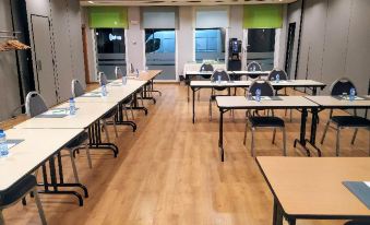 a large conference room with wooden floors and tables set up for a meeting or event at Travelodge Barcelona del Valles