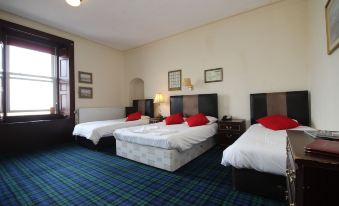 a hotel room with three beds , one on the left , one in the middle , and one on the right at The Anchorage Hotel