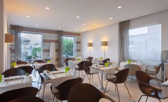 a modern dining room with multiple tables and chairs arranged for a group of people to enjoy a meal together at Hotel Eden