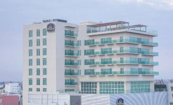 a large hotel building situated on top of a hill , surrounded by trees and other structures at Four Points by Sheraton Veracruz